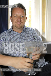 Philip Hensher, author and journalist, with a glass of Retsina at his home in Battersea, South London..©Rogan MacDonald/Writer Pictures/Rosebud2