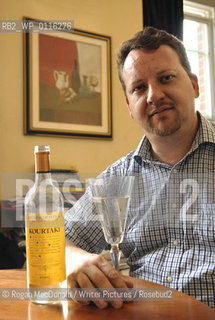 Philip Hensher, author and journalist, with a glass of Retsina at his home in Battersea, South London..©Rogan MacDonald/Writer Pictures/Rosebud2