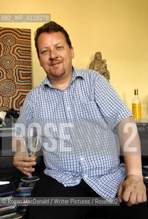 Philip Hensher, author and journalist, with a glass of Retsina at his home in Battersea, South London..©Rogan MacDonald/Writer Pictures/Rosebud2