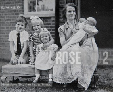 Author Sara Maitland, her isolated cottage in moorland in Galloway in the background. Seen in front of her bookshelf...Collect with her mother and siblings Sara 2nd left (stripe dress, 3 years old).  ..L to R David, Sara, Frippy, mother Hope and baby Jamie (circa 1953.)..29th Oct 2008....Copyright©Robert Perry/TSPL/Writer Pictures/Rosebud2