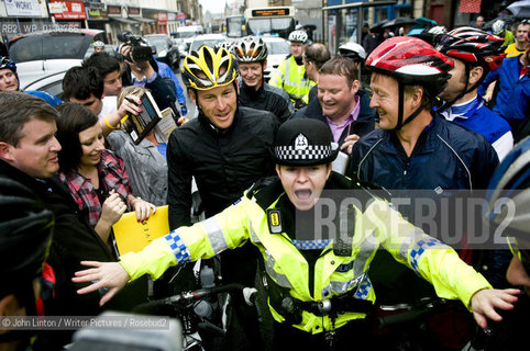 Lance Armstrong cycled in Paisley with around 70 other cyclists after announcing the ride on Twitter..A police woman holds back fans as they try to get books signed and meet their hero, while Lance stands looking bemused...copyright©John Linton/Writer Pictures/Rosebud2