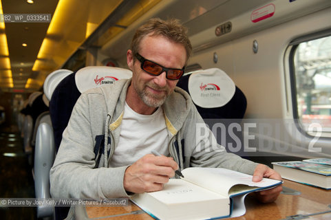 Jo Nesbo taking part in the Virgin Trains High Speed Book Signing at Glasgow Central Station. Bestselling author Jo Nesbo was signing his new addition to the Harry Hole crime fiction series ‘Police’ on the 09.41 Virgin train from Preston to Glasgow. The book was available to purchase on-board from WH Smith representatives, as well as all of the Harry Hole books currently available from WH Smith. A limited number of promotional copies of the first in the Harry Hole series ‘The Bat’ were also available for free. Jo Nesbo was the first in a host of authors to participate in the Virgin Trains High Speed Book Signings campaign which is taking place throughout the UK over the Autumn months. Commuters and book-lovers alike can book their tickets for these one-off experiences from www.virgintrains.com. Joanna Trollope and Ruby Wax will be the next authors on board to sign their new books in the coming months. ..©Picture by Joey Kelly/Writer Pictures/Rosebud2