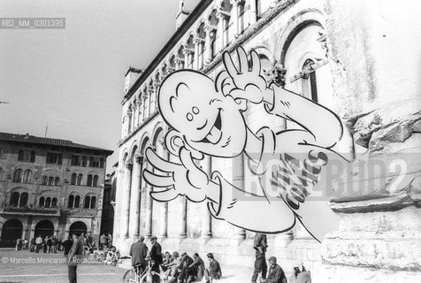 Lucca Comics 1984. A outline of the Yellow Kid character (created by Richard Felton Outcault) in front of the Duomo di San Martino (San Martino Cathedral) / Salone del fumetto di Lucca 1984. Una sagoma del personaggio Yellow Kid (creato da Richard Felton Outcault) davanti al Duomo di San Martino - ©Marcello Mencarini/Rosebud2