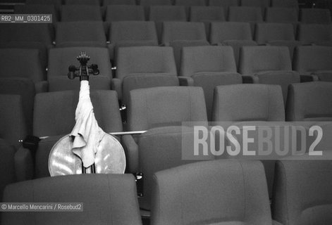 Rome, Pius XII Auditorium at Via della Conciliazione, concert hall of the Santa Cecilia Academy Orchestra. A cello on the chairs (about 1980) / Roma, Auditorium Pio XII in Via della Conciliazione, sede dei concerti dellAccademia di Santa Cecilia. Violoncello sulle sedie (1980 circa) - ©Marcello Mencarini/Rosebud2