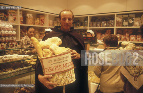 Bologna, 1983. Frati minori dellAntoniano (Franciscan Friars of Saint Anthony). Father Marco Fabbri holding a basket full of Saint Anthonys bread, that is bless bread sold in exchange of offers for charity / Bologna, 1983. Frati minori dellAntoniano. Padre Marco Fabbri con un cesto colmo di pane di SantAntonio, pane benedetto e venduto in cambio di offerte per opere di carità - ©Marcello Mencarini/Rosebud2