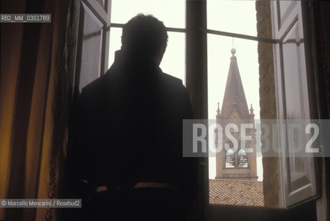 Bologna, 1983. Frati minori dellAntoniano (Franciscan Friars of Saint Anthony). A friar viewed from the back looking out the window  / Bologna, 1983. Frati Minori dellAntoniano. Un frate visto di spalle che guarda da una finestra - ©Marcello Mencarini/Rosebud2