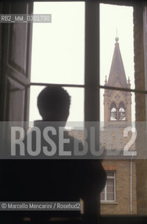 Bologna, 1983. Frati minori dellAntoniano (Franciscan Friars of Saint Anthony). A friar viewed from the back looking out the window  / Bologna, 1983. Frati Minori dellAntoniano. Un frate visto di spalle che guarda da una finestra - ©Marcello Mencarini/Rosebud2