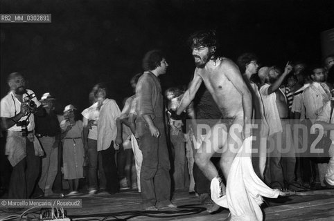 Castelporziano beach, Ostia (Rome), 1979. A naked man among the audience attending the First Festival of the Poets. On the left the photographer Maurizio Bizziccari / Spiaggia di Castel Porziano, Ostia (Roma), 1979. Un uomo nudo tra il pubblico che assiste al primo Festival dei poeti - ©Marcello Mencarini/Rosebud2