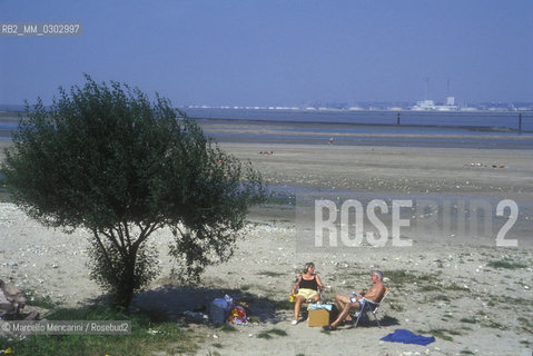 Picnic on the seashore with a factory in the background / Picnic in  riva al mare con fabbrica sullo sfonfo - ©Marcello Mencarini/Rosebud2