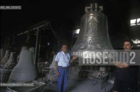 Agnone, Italy, 1999. Pasquale Marinelli, owner of Marinelli Pontifical Bell Foundry, and his nephew Armando near a prototype of the Jubilee 2000 Bell / Agnone (Isernia), 1999. Pasquale Marinelli, proprietario della Pontificia Fonderia Marinelli, e suo nipote Armando jr.vicino a un prototipo della campana del Giubileo 2000 - ©Marcello Mencarini/Rosebud2