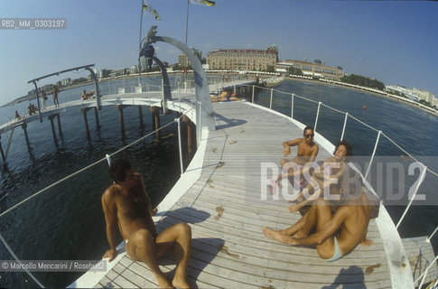 Venice Lido, Venice Film Festival about 1985. Bathers on the dock in front of the Excelsior Hotel / Lido di Venezia, Mostra del Cinema di Venezia 1985 circa. Bagnanti sul pontile dellHotel Excelsior - ©Marcello Mencarini/Rosebud2