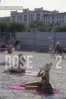 Venice Lido, Venice Film Festival about 1985. Bathers on the beach in front of the Des Bains Hotel / Lido di Venezia, Mostra del Cinema di Venezia 1985 circa. Bagnanti sulla spiaggia davanti allHotel des Bains - ©Marcello Mencarini/Rosebud2