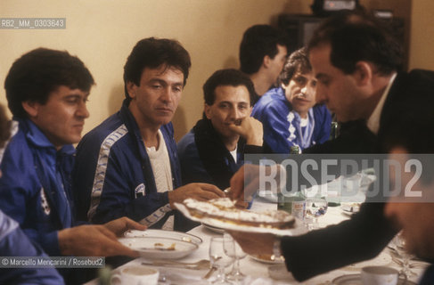 Italian National Singers Football Team, 1987. Italian pop singers Gianni Morandi, Riccardo Fogli and Gianni Bella eat with the team /Nazionale italiana cantanti 1987. I cantanti Gianni Morandi, Riccardo Fogli e Gianni Bella mentre mangiano con la squadra - ©Marcello Mencarini/Rosebud2