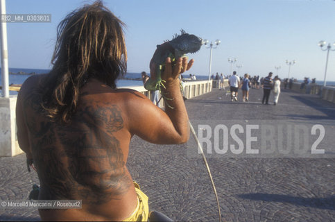 Ostia Lido, 1999. Tattooed man with iguana. Ostia is a beach town near Rome. In the summer time many people from Rome go there to the sea, particularly young suburban people said in slang coatti / Lido di Ostia, 1999. Uomo tatuato con iguana. Ostia è la spiaggia dei romani. Destate è frequentata in particolare dai giovani che abitano le borgate della periferia, i cosiddetti coatti- ©Marcello Mencarini/Rosebud2
