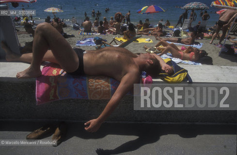 Beach bathers in Ostia Lido, 1999. Ostia is a beach town near Rome. In the summer time many people from Rome go there to the sea, particularly young suburban people said in slang coatti / Bagnanti sul Lido di Ostia, 1999. Ostia è la spiaggia dei romani. Destate è frequentata in particolare dai giovani che abitano le borgate della periferia, i cosiddetti coatti- ©Marcello Mencarini/Rosebud2