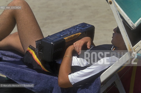 Beach bathers in Ostia Lido, 1999. Ostia is a beach town near Rome. In the summer time many people from Rome go there to the sea, particularly young suburban people said in slang coatti / Bagnanti sul Lido di Ostia, 1999. Ostia è la spiaggia dei romani. Destate è frequentata in particolare dai giovani che abitano le borgate della periferia, i cosiddetti coatti- ©Marcello Mencarini/Rosebud2