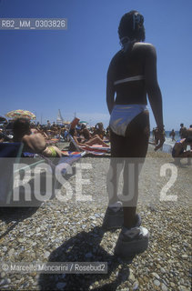 Beach bathers in Ostia Lido, 1999. Ostia is a beach town near Rome. In the summer time many people from Rome go there to the sea, particularly young suburban people said in slang coatti / Bagnanti sul Lido di Ostia, 1999. Ostia è la spiaggia dei romani. Destate è frequentata in particolare dai giovani che abitano le borgate della periferia, i cosiddetti coatti- ©Marcello Mencarini/Rosebud2