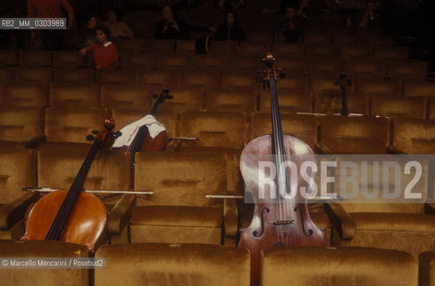 Rome, Pius XII Auditorium at Via della Conciliazione, concert hall of the Santa Cecilia Academy Orchestra. Cellos on the chairs (about 1980) / Roma, Auditorium Pio XII in Via della Conciliazione, sede dei concerti dellAccademia di Santa Cecilia. Violoncelli sulle sedie (1980 circa) - ©Marcello Mencarini/Rosebud2