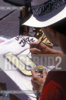 Perugia, Umbria Jazz about 1985. Man painting a t-shirt / Perugia, Umbria Jazz 1985 circa. Uomo che dipinge una maglietta - ©Marcello Mencarini/Rosebud2