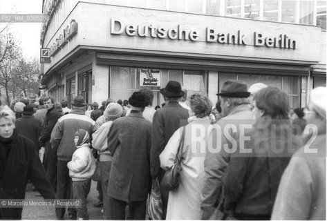 Berlin, 1989. Citizens of the East Germany in the queue at the counter of a West Berlin bank to collect a bonus of 100 marks, gift of the West Germany / Berlino, 1989. Cittadini della Germania Est in coda allo sportello di una banca di Berlino Ovest per riscuotere un bonus di 100 marchi, regalo della Germania Ovest - ©Marcello Mencarini/Rosebud2