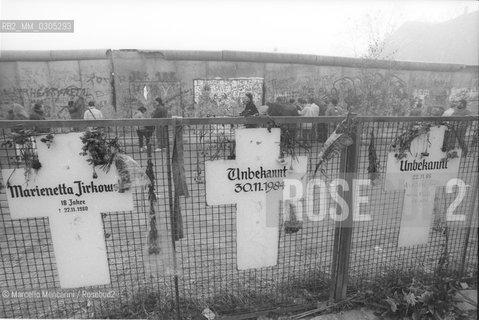 West Berlin, November 1989. The Berlin Wall after the opening of the border between East Germany and West Germany. In the foreground, some cross shape plates in memory of people who died attempting to cross the wall during the Cold War / Berlino Ovest, novembre 1989. Il Muro di Berlino dopo la dichiarazione dellapertura delle frontiere tra Germania Est e Germania Ovest. In primo piano, alcune targhe a forma di croce in memoria delle persone che cercarono di oltrepassare il muro durante la guerra fredda - ©Marcello Mencarini/Rosebud2