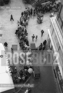 East Berlin, 1989. Citizens of the East Germany in the queue at the mobile counter of a West Berlin bank to collect a bonus of 100 marks, gift of the West Germany after the opening of the border between East Germany and West Germany / Berlino Est, 1989. Cittadini della Germania Est in coda allo sportello mobile di una banca di Berlino Ovest per riscuotere un bonus di 100 marchi, regalo della Germania Ovest dopo lapertura delle frontiere tra Germania Est e Germania Ovest - ©Marcello Mencarini/Rosebud2