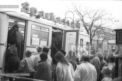 West Berlin, 1989. Citizens of the East Germany in the queue at the mobile counter of a West Berlin bank to collect a bonus of 100 marks, gift of the West Germany after the opening of the border between East Germany and West Germany / Berlino Ovest, 1989. Cittadini della Germania Est in coda allo sportello mobile di una banca di Berlino Ovest per riscuotere un bonus di 100 marchi, regalo della Germania Ovest dopo lapertura delle frontiere tra Germania Est e Germania Ovest - ©Marcello Mencarini/Rosebud2