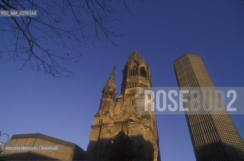 West Berlin, 1989. The Kaiser Wilhelm Memorial Church (Gedächtniskirche), partially destroyed during a bombing raid in 1943, along with its modern additions, on the Kurfürstendamm in the centre of the Breitscheidplatz / Berlino Ovest, 1989. La Chiesa commemorativa dellImperatore Guglielmo (Gedächtniskirche), costituita dalle rovine  della chiesa distrutta dai bombardamenti durante la guerra e da costruzioni contemporanee, sul Kurfürstendamm al centro di Breitscheidplatz - ©Marcello Mencarini/Rosebud2