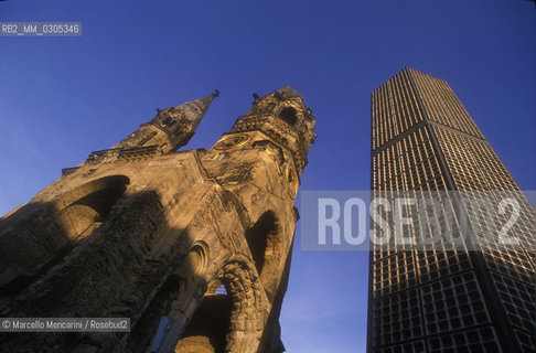 West Berlin, 1989. The Kaiser Wilhelm Memorial Church (Gedächtniskirche), partially destroyed during a bombing raid in 1943, along with its modern additions, on the Kurfürstendamm in the centre of the Breitscheidplatz / Berlino Ovest, 1989. La Chiesa commemorativa dellImperatore Guglielmo (Gedächtniskirche), costituita dalle rovine  della chiesa distrutta dai bombardamenti durante la guerra e da costruzioni contemporanee, sul Kurfürstendamm al centro di Breitscheidplatz - ©Marcello Mencarini/Rosebud2