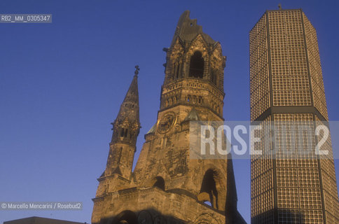 West Berlin, 1989. The Kaiser Wilhelm Memorial Church (Gedächtniskirche), partially destroyed during a bombing raid in 1943, along with its modern additions, on the Kurfürstendamm in the centre of the Breitscheidplatz / Berlino Ovest, 1989. La Chiesa commemorativa dellImperatore Guglielmo (Gedächtniskirche), costituita dalle rovine  della chiesa distrutta dai bombardamenti durante la guerra e da costruzioni contemporanee, sul Kurfürstendamm al centro di Breitscheidplatz - ©Marcello Mencarini/Rosebud2
