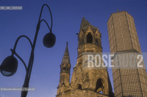 West Berlin, 1989. The Kaiser Wilhelm Memorial Church (Gedächtniskirche), partially destroyed during a bombing raid in 1943, along with its modern additions, on the Kurfürstendamm in the centre of the Breitscheidplatz / Berlino Ovest, 1989. La Chiesa commemorativa dellImperatore Guglielmo (Gedächtniskirche), costituita dalle rovine  della chiesa distrutta dai bombardamenti durante la guerra e da costruzioni contemporanee, sul Kurfürstendamm al centro di Breitscheidplatz - ©Marcello Mencarini/Rosebud2