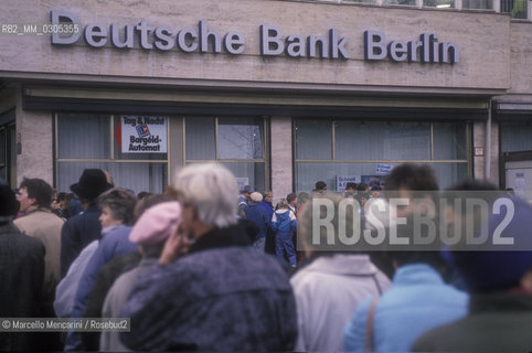 East Berlin, 1989. Citizens of the East Germany in the queue at the counter of a West Berlin bank to collect a bonus of 100 marks, gift of the West Germany after the opening of the border between East Germany and West Germany / Berlino Est, 1989. Cittadini della Germania Est in coda allo sportello di una banca di Berlino Ovest per riscuotere un bonus di 100 marchi, regalo della Germania Ovest dopo lapertura delle frontiere tra Germania Est e Germania Ovest - ©Marcello Mencarini/Rosebud2