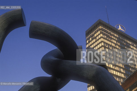 West Berlin, 1989. Berlin sculpture by Brigitte Matschinsky-Denninghoff and Martin Matschinsky, unveeiled in 1987 on Tauentzienstrasse. The sculptures principal motif, a broken chain, was meant to symbolize the severed connections between West and East Berlin due to the construction of the Berlin Wall. In the background the Mercedes-Benz head office / Berlino Ovest, 1989. La scultura Berlin dei coniugi Brigitte Matschinsky-Denninghoff e Martin Matschinsky inaugurata nel 1987 in Tauentzienstrasse. La catena spezzata, che è il motivo principale dellopera, simboleggia le connessioni interrotte tra Est e Ovest per la costruzione del muro di Berlino. Sullo sfondo, la sede della Mercedes Benz - ©Marcello Mencarini/Rosebud2