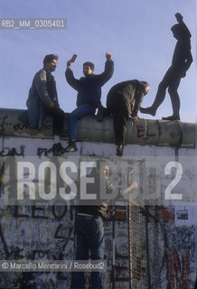 West Berlin, November 1989. The Berlin Wall fall: people who cross the Wall after the opening of the border between East Germany and West Germany / Berlino Ovest, novembre 1989. Caduta del muro di Berlino: persone che scavalcano il muro dopo lapertura delle frontiere tra Germania Est e Germania Ovest - ©Marcello Mencarini/Rosebud2