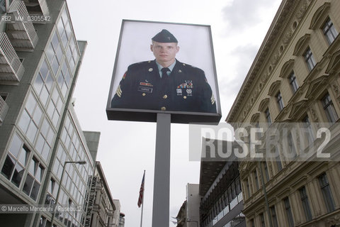 Berlin, 2005. Poster with a picture of an US soldier at the Checkpoint Charlie, that was a crossing point between East and West Berlin during the Cold War, now  a tourist attraction. This side of the poster is viewed from the former Soviet sector. The reverse side, viewed from the former US sector, shows a Soviet soldier / Berlino, 2005. Manifesto con limmagine di un soldato americano presso il Checkpoint Charlie, che durante la guerra fredda era uno dei più famosi posti di blocco sulla frontiera tra Berlino Est e Berlino Ovest. Questo lato del manifesto si vede dallex settore sovietico, mentre sul lato opposto, visto dal settore americano, si vede limmagine di un soldato sovietico - ©Marcello Mencarini/Rosebud2