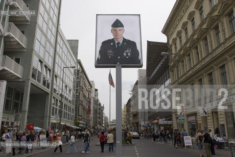 Berlin, 2005. Poster with a picture of an US soldier at the Checkpoint Charlie, that was a crossing point between East and West Berlin during the Cold War, now  a tourist attraction. This side of the poster is viewed from the former Soviet sector. The reverse side, viewed from the former US sector, shows a Soviet soldier / Berlino, 2005. Manifesto con limmagine di un soldato americano presso il Checkpoint Charlie, che durante la guerra fredda era uno dei più famosi posti di blocco sulla frontiera tra Berlino Est e Berlino Ovest. Questo lato del manifesto si vede dallex settore sovietico, mentre sul lato opposto, visto dal settore americano, si vede limmagine di un soldato sovietico - ©Marcello Mencarini/Rosebud2