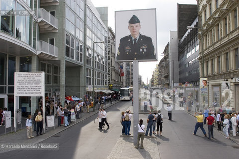 Berlin, 2005. Poster with a picture of an US soldier at the Checkpoint Charlie, that was a crossing point between East and West Berlin during the Cold War, now  a tourist attraction. This side of the poster is viewed from the former Soviet sector. The reverse side, viewed from the former US sector, shows a Soviet soldier / Berlino, 2005. Manifesto con limmagine di un soldato americano presso il Checkpoint Charlie, che durante la guerra fredda era uno dei più famosi posti di blocco sulla frontiera tra Berlino Est e Berlino Ovest. Questo lato del manifesto si vede dallex settore sovietico, mentre sul lato opposto, visto dal settore americano, si vede limmagine di un soldato sovietico - ©Marcello Mencarini/Rosebud2