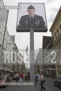Berlin, 2005. Poster with a picture of an US soldier at the Checkpoint Charlie, that was a crossing point between East and West Berlin during the Cold War, now  a tourist attraction. This side of the poster is viewed from the former Soviet sector. The reverse side, viewed from the former US sector, shows a Soviet soldier / Berlino, 2005. Manifesto con limmagine di un soldato americano presso il Checkpoint Charlie, che durante la guerra fredda era uno dei più famosi posti di blocco sulla frontiera tra Berlino Est e Berlino Ovest. Questo lato del manifesto si vede dallex settore sovietico, mentre sul lato opposto, visto dal settore americano, si vede limmagine di un soldato sovietico - ©Marcello Mencarini/Rosebud2