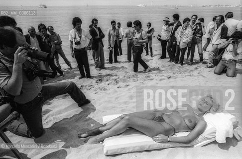 37th Cannes Film Festival, 1984. Photographers shooting a topless starlet on the beach / 37° Festival del Cinema di Cannes, 1984. Fotografi intorno a una starlette in topless sulla spiaggia - ©Marcello Mencarini/Rosebud2