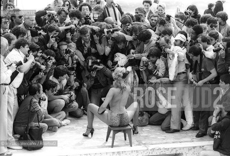 37th Cannes Film Festival, 1984. Photographers shooting a topless starlet on the beach of the Carlton Hotel / 37° Festival del Cinema di Cannes, 1984. Fotografi intorno a una starlette in topless sulla spiaggia dellHotel Carlton - ©Marcello Mencarini/Rosebud2