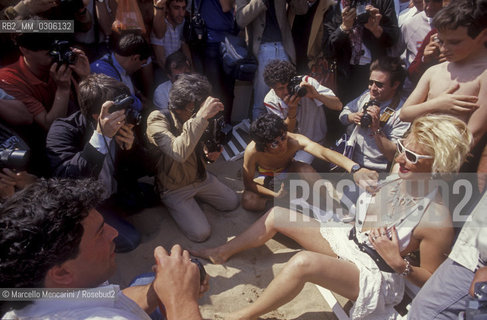 37th Cannes Film Festival, 1984. Photographers shooting a  starlet on the beach / 37° Festival di Cannes, 1984. Fotografi intorno a una starlette sulla spiaggia - ©Marcello Mencarini/Rosebud2