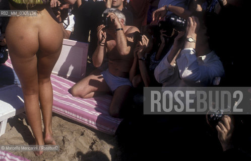37th Cannes Film Festival, 1984. Photographers shooting a naked starlet on the beach / 37° Festival di Cannes, 1984. Fotografi intorno a una starlette nuda sulla spiaggia - ©Marcello Mencarini/Rosebud2