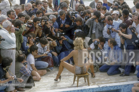 37th Cannes Film Festival, 1984. Photographers shooting a starlet on the beach / 37° Festival di Cannes, 1984. Fotografi intorno a una starlette sulla spiaggia - ©Marcello Mencarini/Rosebud2