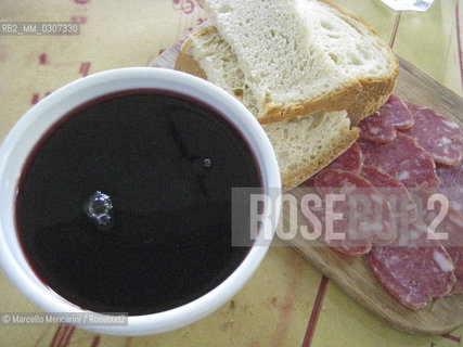 Milan, 2008. A traditional cup of red wine Bonarda, salami and some slices of bread at the Salsamenteria Verdiana, a restaurant at 52 Foro Bonaparte, decorated in the style of the old “salsamenterie”, or delicatessens, in the late 1800s. Salsamenteria Verdiana serves the best preserved meats, prepared dishes, cheeses and wines of the area around Parma. The strains of Maestro Giuseppe Verdi accompany each meal / Milano, 2008. Una tazza di vino rosso Bonarda (il vino nella zona di Parma si beveva in tazza), salame e fette di pane alla Salsamenteria Verdiana in Foro Bonaparte 52. Il ristorante Salsamenteria Verdiana porta in tavola salumi,  pietanze calde, formaggi e vini della terra di Parma. I locali della Salsamenteria Verdiana sono nel tipico stile delle antiche Salsamenterie di fine 1800. Durante il pasto vengono trasmesse le melodie del Maestro Giuseppe Verdi - ©Marcello Mencarini/Rosebud2