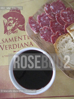 Milan, 2008. A traditional cup of red wine Bonarda, salami and some slices of bread at the Salsamenteria Verdiana, a restaurant at 52 Foro Bonaparte, decorated in the style of the old “salsamenterie”, or delicatessens, in the late 1800s. Salsamenteria Verdiana serves the best preserved meats, prepared dishes, cheeses and wines of the area around Parma. The strains of Maestro Giuseppe Verdi accompany each meal / Milano, 2008. Una tazza di vino rosso Bonarda (il vino nella zona di Parma si beveva in tazza), salame e fette di pane alla Salsamenteria Verdiana in Foro Bonaparte 52. Il ristorante Salsamenteria Verdiana porta in tavola salumi,  pietanze calde, formaggi e vini della terra di Parma. I locali della Salsamenteria Verdiana sono nel tipico stile delle antiche Salsamenterie di fine 1800. Durante il pasto vengono trasmesse le melodie del Maestro Giuseppe Verdi - ©Marcello Mencarini/Rosebud2