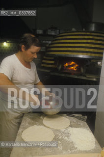 Naples, Italy. Preparation of Pizza Margherita at Brandi pizza restaurant, where in 1889 it was invented in honour of Queen Margaret (Margherita) of Savoy, Third step: spread pizza sauce (made ​​with tomatoes and basil) on the crust / Napoli, Preparazione della pizza Margherita nella Pizzeria Brandi, dove nel 1889 fu inventata in onore della regina Margherita di Savoia. Terza fase: stendere il sugo (a base di pomodoro e basilico) sulla pasta - ©Marcello Mencarini/Rosebud2