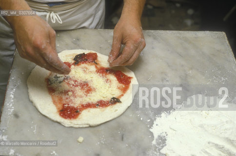 Naples, Italy. Preparation of Pizza Margherita at Brandi pizza restaurant, where in 1889 it was invented in honour of Queen Margaret (Margherita) of Savoy. Fourth step: sprinkle with grated Parmesan cheese / Napoli, Preparazione della pizza Margherita nella Pizzeria Brandi, dove nel 1889 fu inventata in onore della regina Margherita di Savoia. Quarta fase: cospargere con parmigiano grattugiato - ©Marcello Mencarini/Rosebud2
