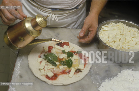Naples, Italy. Preparation of Pizza Margherita at Brandi pizza restaurant, where in 1889 it was invented in honour of Queen Margaret (Margherita) of Savoy. Sixth step: add a little olive oil / Napoli, Preparazione della pizza Margherita nella Pizzeria Brandi, dove nel 1889 fu inventata in onore della regina Margherita di Savoia. Sesta fase: aggiungere un filo dolio - ©Marcello Mencarini/Rosebud2