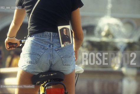 Pesaro, Rossini Opera Festival 1997. A cyclist in hot pants with the festival program in her pocket / Pesaro, Rossini Opera Festival, 1997. Una ciclista in hot pants con il programma del festival in tasca - ©Marcello Mencarini/Rosebud2