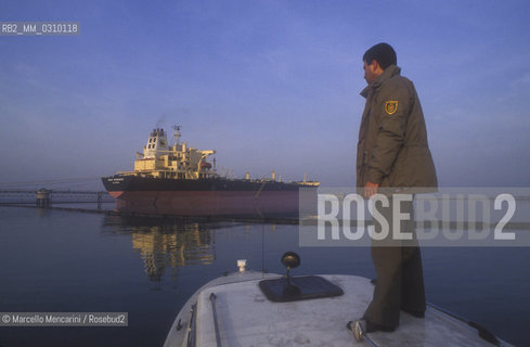 Venice, San Leonardo Port, about 1990. A guard of the Venice lagoon and, in the background, a tanker unloading / Venezia, porto di San Leonardo, 1990 circa. Guardia lagunare e, sullo sfondo, petroliera durante lo scarico - ©Marcello Mencarini/Rosebud2